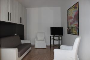 a living room with a couch and two chairs and a tv at Casa Lia in Lesa