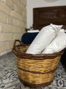 una cesta con almohadas blancas en el suelo en Zia Marietta Guest House, en Altamura