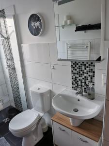 a bathroom with a white toilet and a sink at Liebevoll eingerichtete Ferienwohnung - Zentrale Lage - Netflix & Paytv in Wilhelmshaven