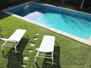 two chairs sitting next to a swimming pool at Cobre Cascais in Cascais
