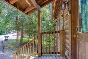 a porch of a wooden house with a door and trees at Awesome Honey Bear- Get 951 worth of FREE area attraction tickets for each paid day!!! in Sevierville