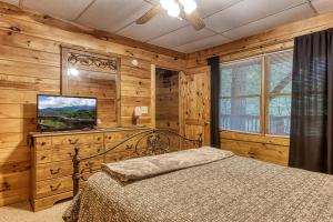a bedroom with a bed in a room with wooden walls at Awesome Honey Bear- Get 951 worth of FREE area attraction tickets for each paid day!!! in Sevierville