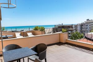 a balcony with a table and chairs and the ocean at Hotel Nettunia in Rimini