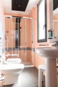a bathroom with a toilet and a sink and a shower at Hotel Nettunia in Rimini
