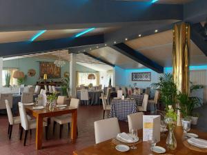 jadalnia ze stołami i krzesłami oraz niebieskimi sufitami w obiekcie Hotel Don Gonzalo w mieście Montilla