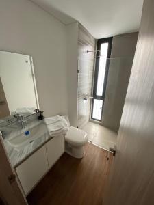 een badkamer met een toilet, een wastafel en een spiegel bij Apartamento Bogota Centro Internacional in Bogota