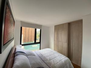 een slaapkamer met een bed en een groot raam bij Apartamento Bogota Centro Internacional in Bogota +33 foto's
