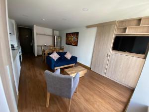 een woonkamer met een blauwe bank en een tafel bij Apartamento Bogota Centro Internacional in Bogota