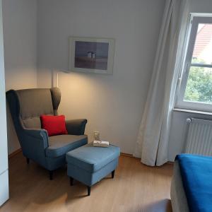 a living room with a chair and a red pillow at 2-Zimmer-Fewo Nähe Lübeck in Berkenthin