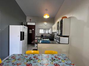 a kitchen with a table and two chairs and a refrigerator at Chalés Praias Brasileiras in Maragogi