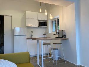 a kitchen with a refrigerator and a counter with stools at Charmant Studio dans villa - parking - jardin in La Seyne-sur-Mer