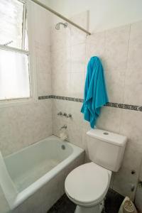 uma casa de banho com um WC, uma banheira e uma toalha azul em Departamento en Buenos Aires em Buenos Aires