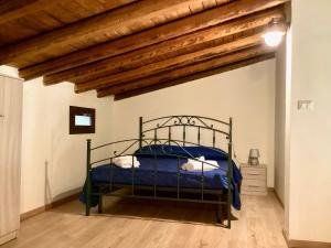 una camera da letto con letto in metallo e lenzuola blu di Casale Ciricó tra Catania e Siracusa a Carlentini