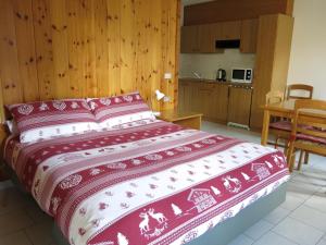 a bedroom with a large bed and a kitchen at Baita al Pian in Bormio