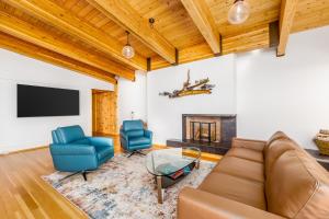 Una sala de estar con un sofá y sillas y un televisor. en Downtown Oceanview Luxury Home, en Anchorage