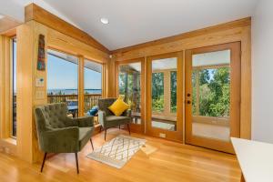 a living room with two chairs and windows at Downtown Oceanview Luxury Home in Anchorage
