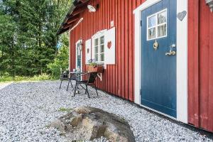 a red house with a blue door and a table at Höga Backe Gästhus in Asphyttan