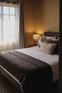 une chambre avec un grand lit avec une fenêtre dans l'établissement Bodegas Vaivén Hotel Boutique, à Tequisquiapan