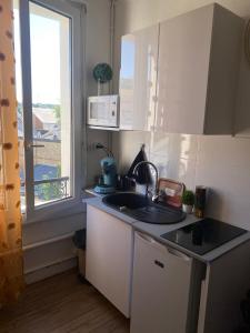 una pequeña cocina con fregadero y ventana en Studio le Métropole Centre ville en Deauville
