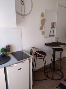a small kitchen with two stools and a table at Studio le Métropole Centre ville in Deauville