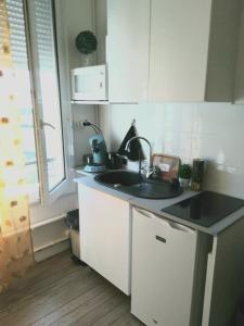 una pequeña cocina con fregadero y ventana en Studio le Métropole Centre ville en Deauville