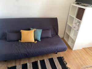 un sofá azul con almohadas en la sala de estar en Studio le Métropole Centre ville en Deauville