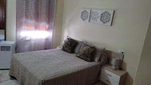 um quarto com uma cama e uma janela em Apartamento Puerta Nueva em Córdoba