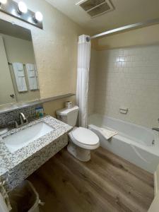 a bathroom with a sink and a toilet and a tub at Travelodge by Wyndham Imperial - El Centro in El Centro