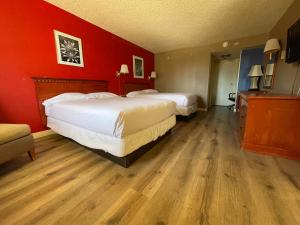 two beds in a hotel room with red walls at Travelodge by Wyndham Imperial - El Centro in El Centro