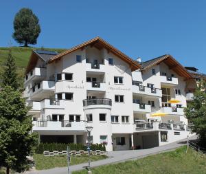 duży biały budynek z balkonami i drzewami w obiekcie Aparthotel Alpendiamant Serfaus Wachter GmbH w mieście Serfaus