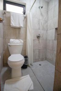 a bathroom with a toilet and a shower at Hotel Tequila Cancun in Cancún