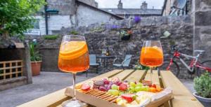 two glasses of orange juice and a box of fruit on a table at Cosy ground floor Flat - Kendal Lake District with bike storage in Kendal