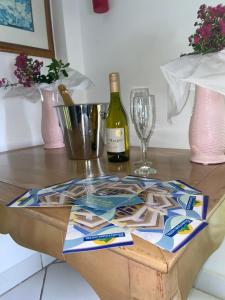 uma mesa com uma garrafa de vinho e um copo em The Downtown Hotel em Soufrière