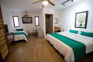 Cette chambre d'hôtel comprend 2 lits avec des draps verts. dans l'établissement Hotel Tequila Cancun, à Cancún