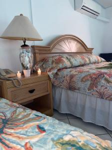 sypialnia z 2 łóżkami i lampką na stoliku nocnym w obiekcie The Downtown Hotel w mieście Soufrière