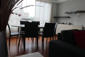 een eetkamer met een tafel en stoelen en een raam bij Elegante Flat en inmejorable ubicación - San Isidro in Lima