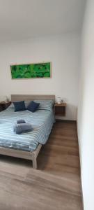 Un dormitorio con una cama con una pintura verde encima. en Agriturismo Ca' du Nibile di Bove Gabriele, en Carbuta