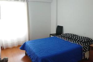 een slaapkamer met een blauw bed en een raam bij Elegante Flat en inmejorable ubicación - San Isidro in Lima