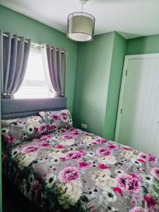 a bedroom with a bed with flowers on it at Violet House in Derry Londonderry