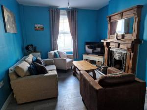 een woonkamer met een bank en een open haard bij Violet House in Derry Londonderry