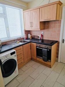 a kitchen with a stove and a sink and a microwave at Violet House in Derry Londonderry