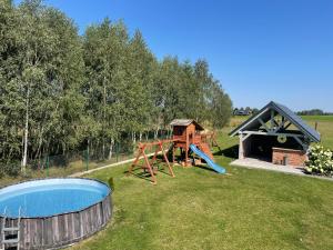 a playground with a slide and a house at Pogodna Zagroda-Dom na Kaszubach & Strefa Spa in Kościerzyna