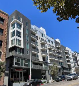 un gran edificio de apartamentos con coches aparcados frente a él en DTLA home away en Los Ángeles