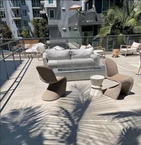 a couch sitting on a patio with two chairs at DTLA home away in Los Angeles