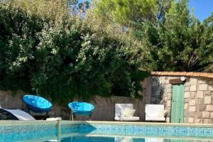 ein Pool mit einigen blauen Stühlen und einem Zaun in der Unterkunft Le clos Roby maison avec piscine proche du centre historique in Pézenas