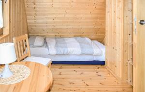 a small room with a bed in a wooden cabin at Awesome Home In Bobolin With Kitchen in Bobolin