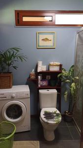 a bathroom with a toilet and a washing machine at Tiki House in Bora Bora