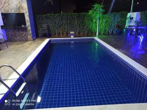 a swimming pool at night with a blue tiled floor at Casa alto padrão Capitólio Lago Vitória in Capitólio