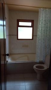 La salle de bains est pourvue d'une baignoire, de toilettes et d'une fenêtre. dans l'établissement BS HOTEL CAMPESTRE, à Cucunubá