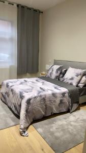 una camera da letto con un grande letto con un piumone grigio di Kechmara hammam&spa a Lille
